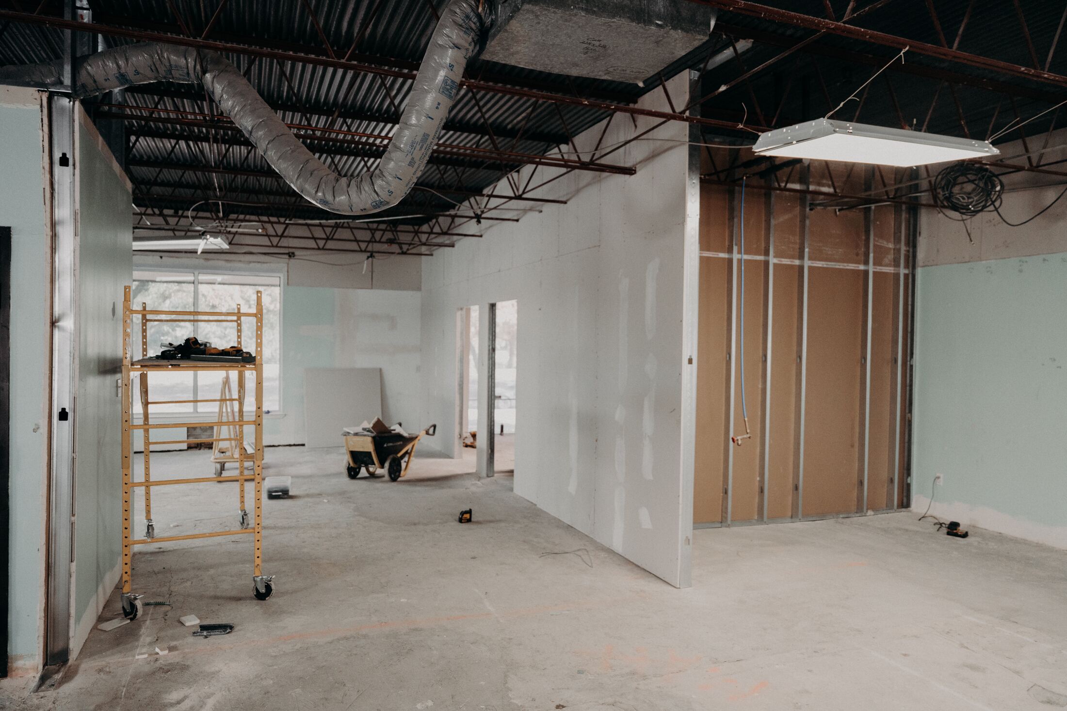 Gutted suite with exposed ceiling grid before renovation