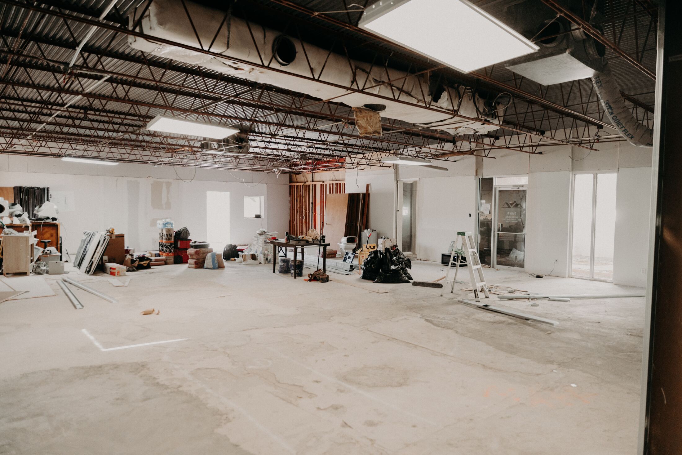 Empty gutted room showing exposed structural ceiling grid