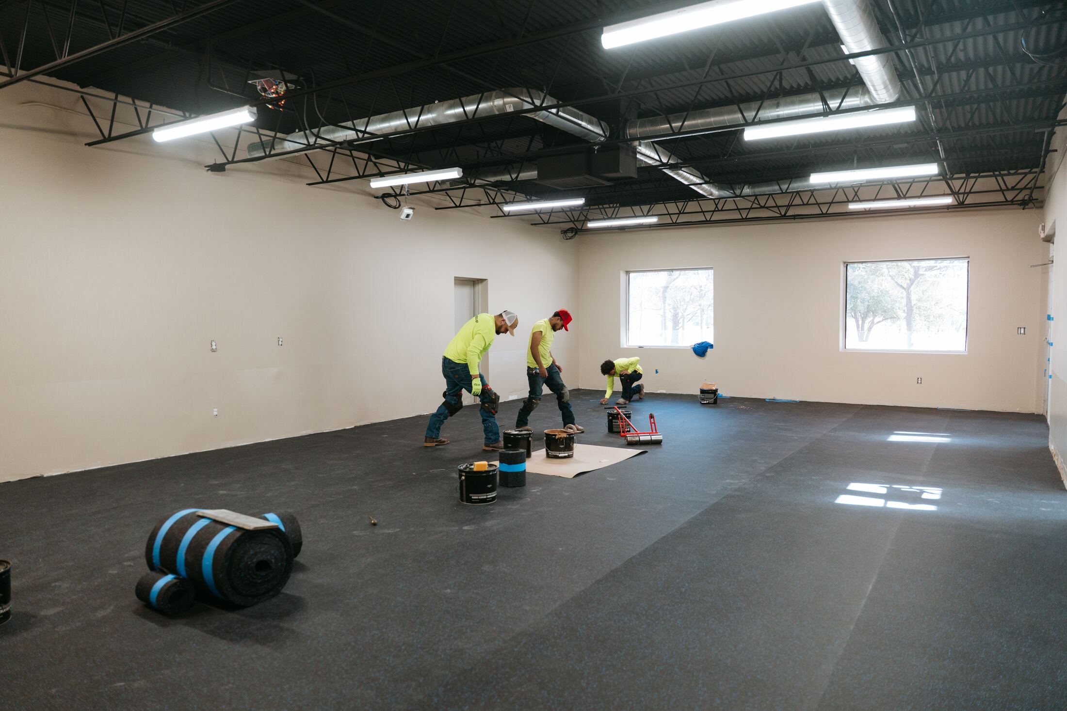 Resolver crew rolling out rubber flooring in the future training room